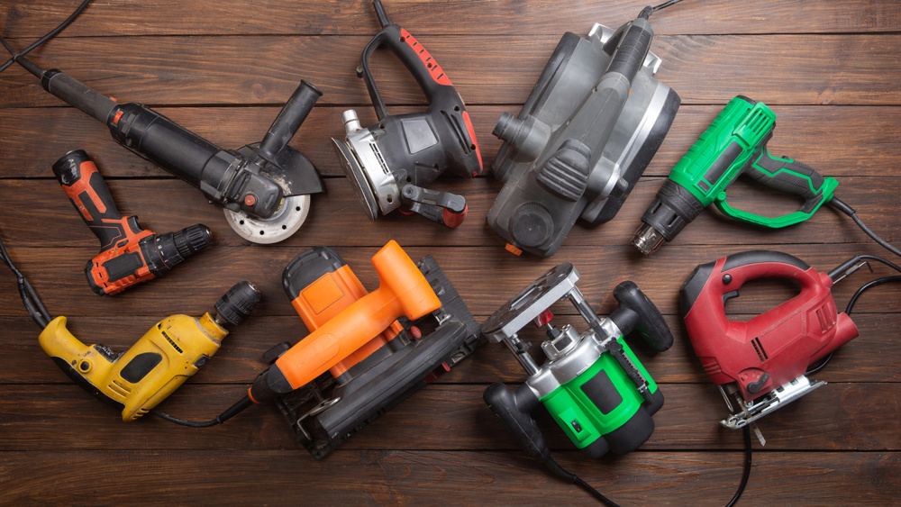 Set of electric tools on the wooden table. Various power tools for renovation and construction, top view